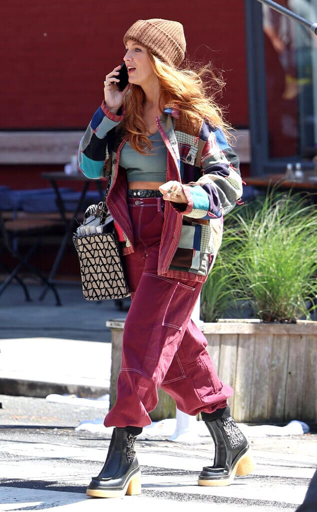 Blake Lively wearing a patchwork jacket and maroon carpenter pants as Lily Bloom in movie adaptation of Colleen Hoover's book "It Ends with Us"