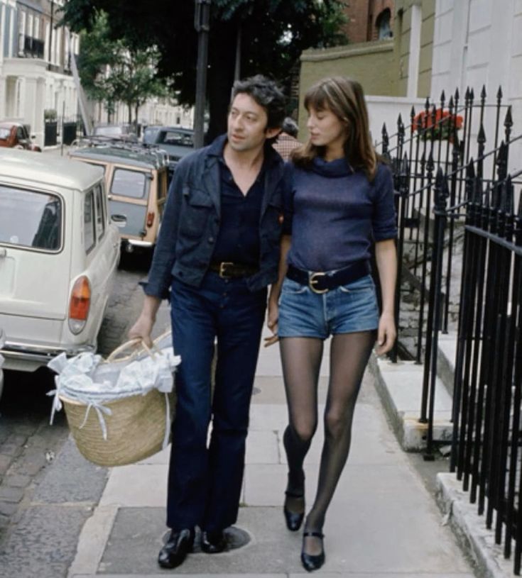 streetstyle shot of jane birkin and Serge Gainsbourg carrying baby in basket walking the streets of France