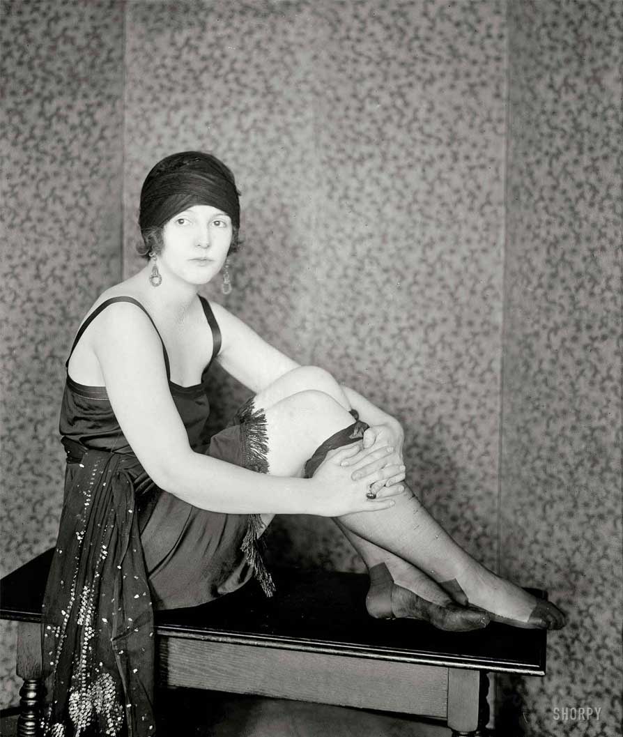 Young woman flapper Madame F wearing a hat and a tank top flapper dress and sheer stockings